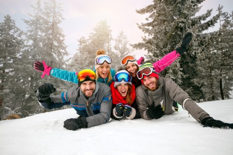 friends on winter holidays Ã¢?? Happy skiers lying on snow and having fun